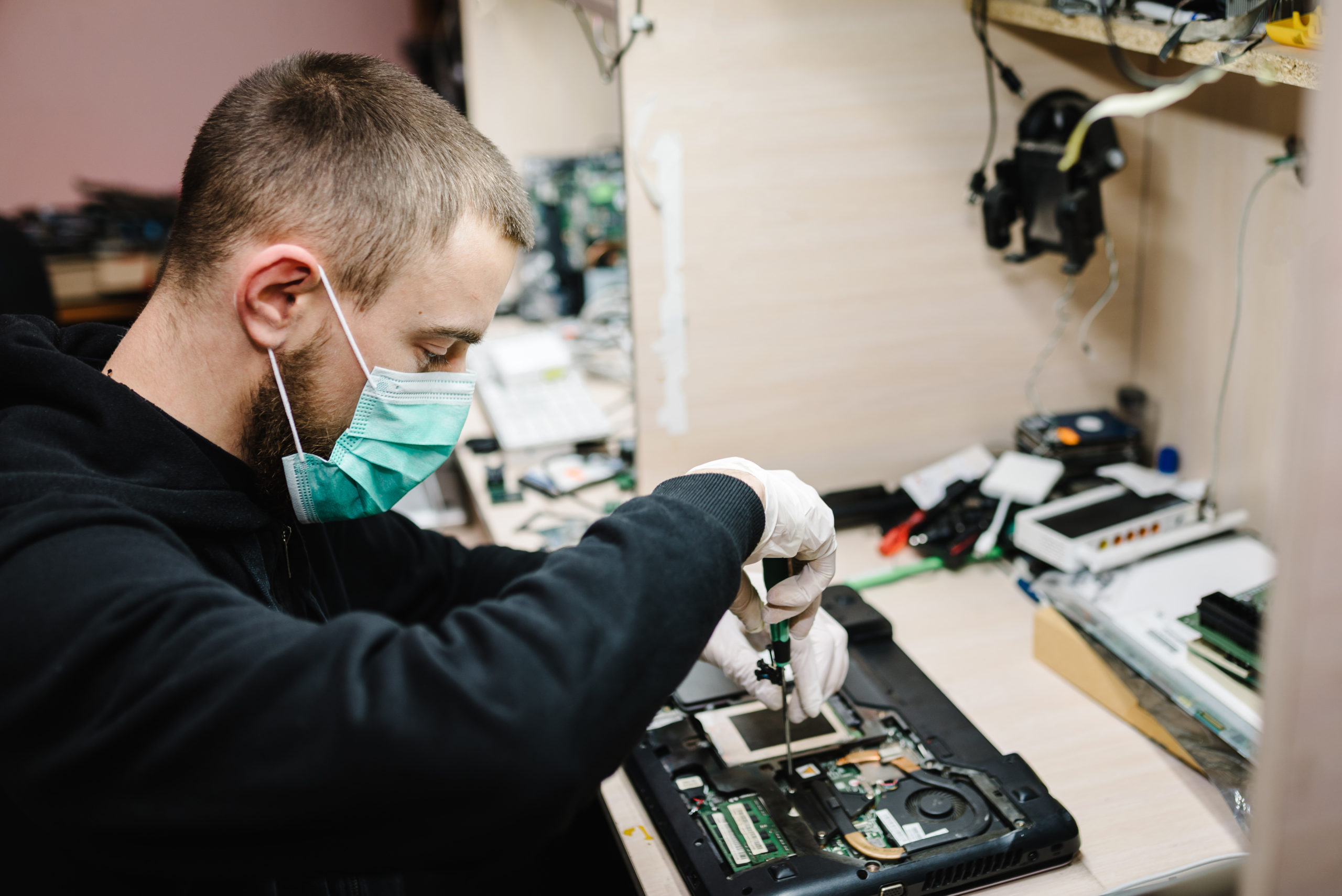 Technicien réparant un ordinateur portable en laboratoire.